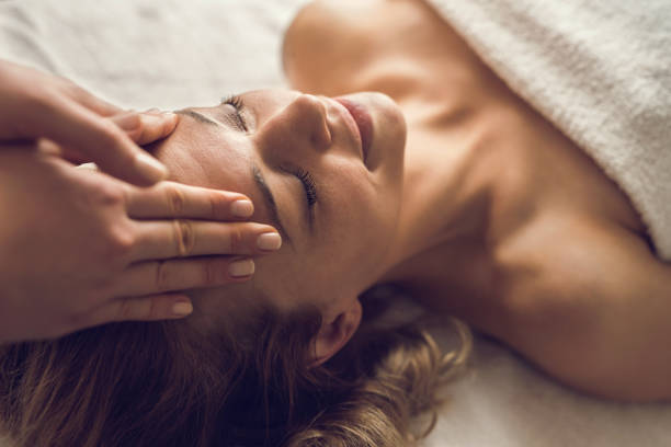 w połowie dorosłej kobiety korzystających w jej relaksujący masaż głowy w spa. - head massage zdjęcia i obrazy z banku zdjęć
