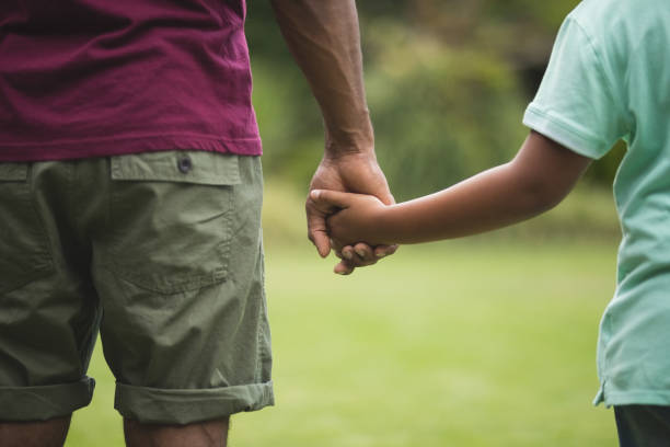 istock Mid section of father and son holding hands 804292764
