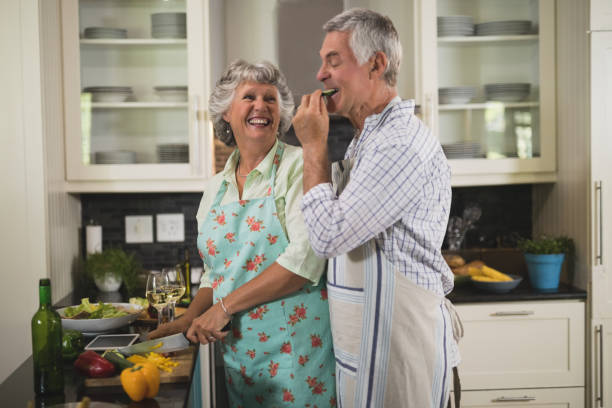 istock Playful senior couple enjoying while cooking in kitchen 804295212