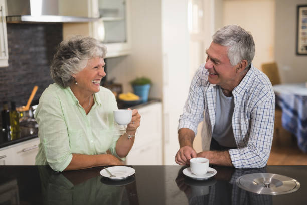 istock Senior couple looking at each other while having coffee at home 804295478