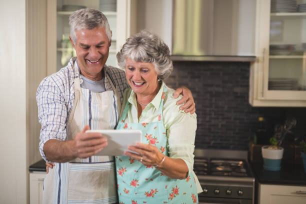 istock Happy senior couple watching digital tablet in kitchen 804304898