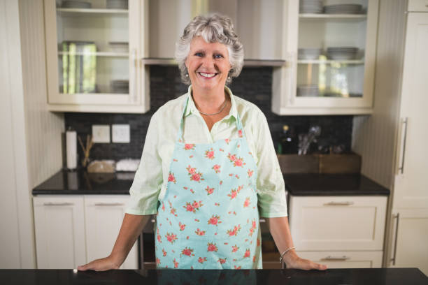 istock Smiling senior woman standing in kitchen at home 804305430