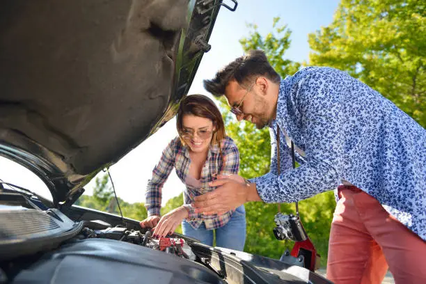 Photo of Young couple on the road has problems with their car