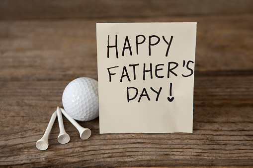 Happy fathers day message with sports equipments on wooden plank