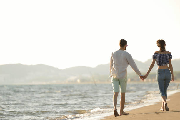istock happy couple waling on the beach and having fun 804308418
