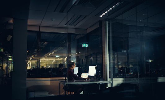 Shot of a businessman working late in an office