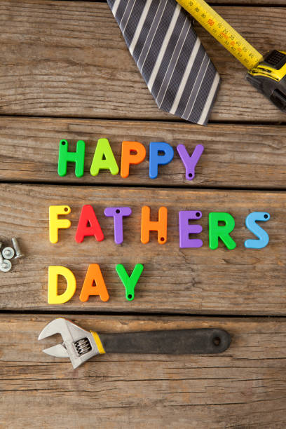 istock Happy fathers day blocks, tie, measuring tape and handtools on wooden plank 804316650
