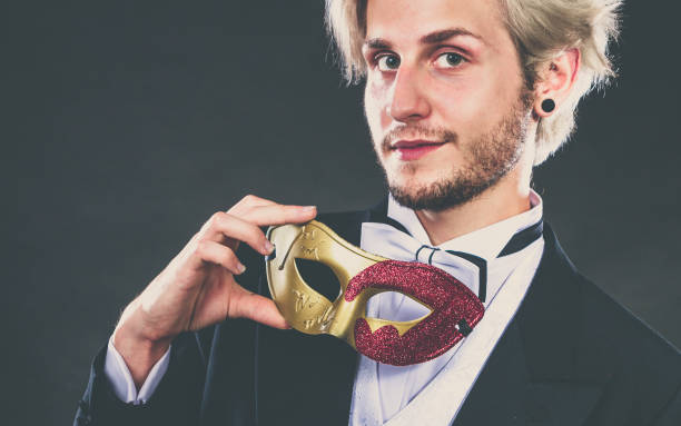 istock Young man in carnival mask on dark 804335636