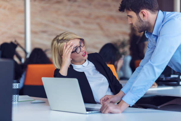 istock Colleagues chatting, sitting together at office table, smiling 804335898