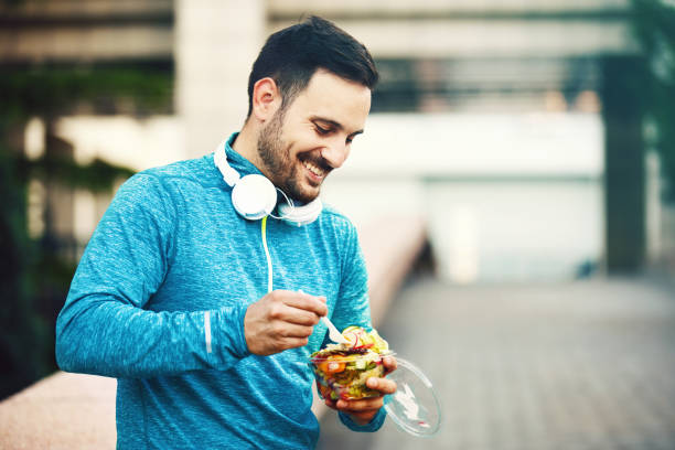 Man is eating fruit salad stock photo