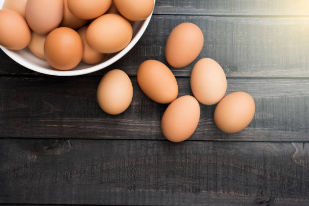 istock Fresh hen egg in white bowl and 6 hen egg out side on Black color wood table 804346510