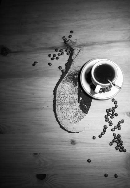 coffee time - old vintage retro image of cup of black hot coffee smelling good with roasted coffee beans top view on wooden background with copy space in black and white
