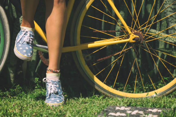 Women's beautiful legs standing with old bicycle outdoors. Women's beautiful legs standing with old bicycle outdoors. pedal bin stock pictures, royalty-free photos & images