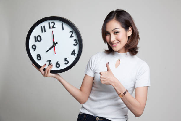 istock Young Asian woman thumbs up with a clock. 804358866