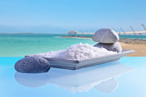 istock Sea salt on a glass table with stones and cockleshells 804359074