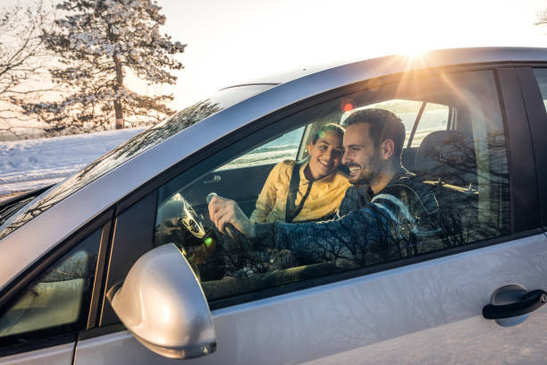 young happy couple going on a road trip during winter day. - winter driving imagens e fotografias de stock