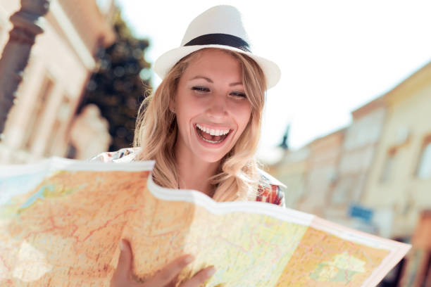 istock Happy young woman using a city map 804384376