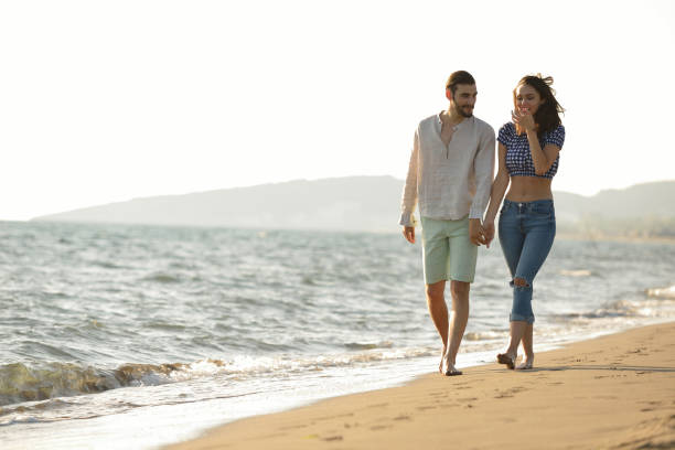 istock happy couple waling on the beach and having fun 804384798