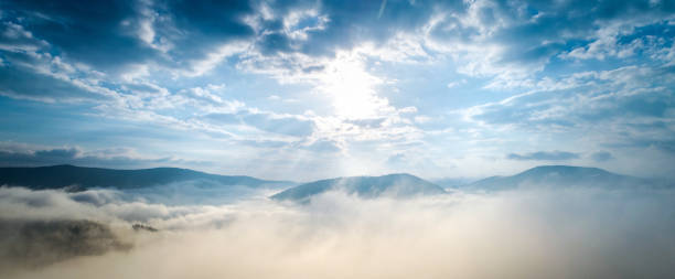 luftaufnahme von bergdorf unter wolken - carpathian mountain range stock-fotos und bilder