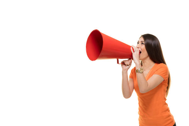 молодая женщина кричит в мегафон. - announcement message megaphone public speaker women стоковые фото и изображения