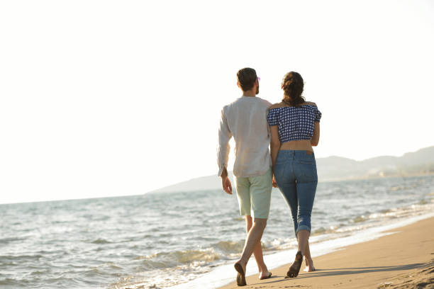 istock happy couple waling on the beach and having fun 804392742