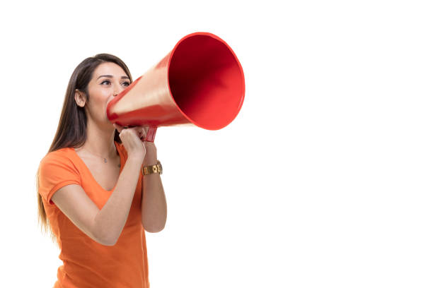 молодая женщина кричит в мегафон. - announcement message megaphone public speaker women стоковые фото и изображения