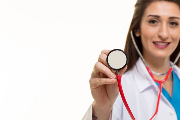Curious pretty woman listening heartbeat with stethoscope while looking away