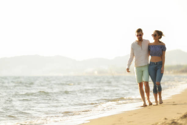 istock happy couple waling on the beach and having fun 804410582