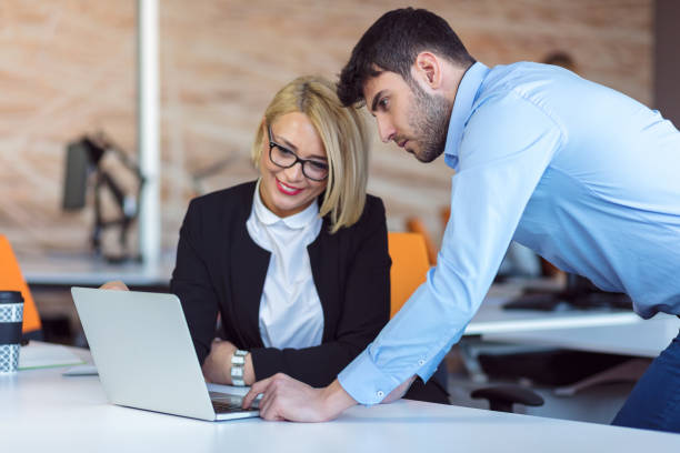 istock Colleagues chatting, sitting together at office table, smiling 804423468