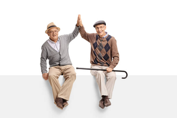 istock Two elderly men seated on a panel high-fiving each other 804427070