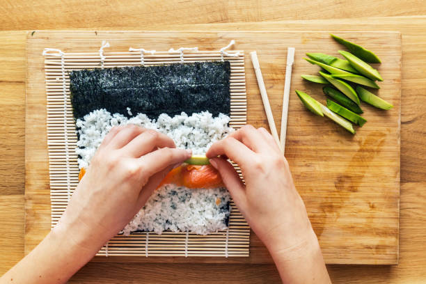 istock Preparing sushi. Salmon, avocado, rice and chopsticks on wooden table. 804432106