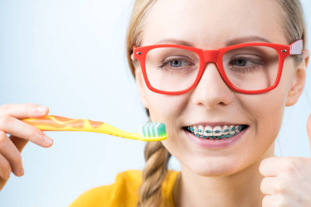 istock Woman smiling cleaning teeth with braces 804439972