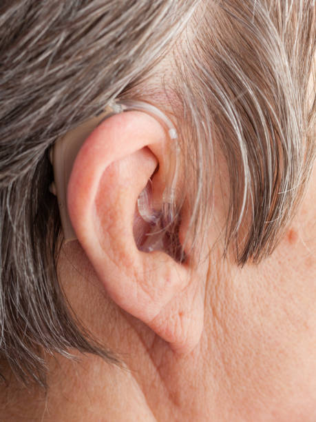 istock Closeup senior woman using hearing aid 804444840