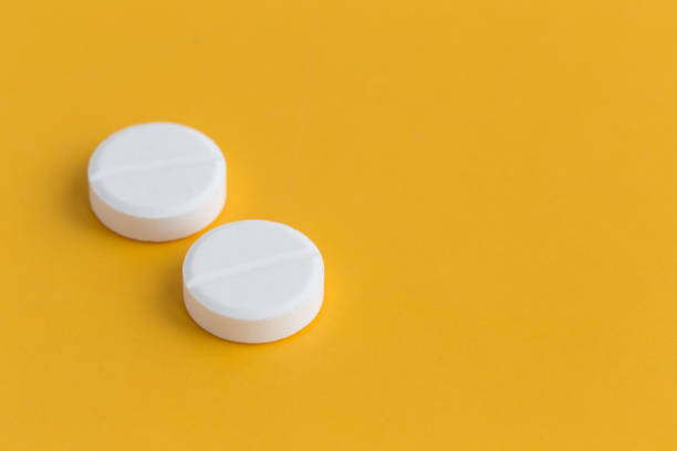 istock WHITE PILLS ON YELLOW BACKGROUND CONCEPT 804454848