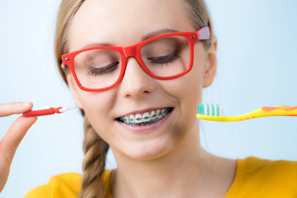 istock Woman smiling cleaning teeth with braces 804455840