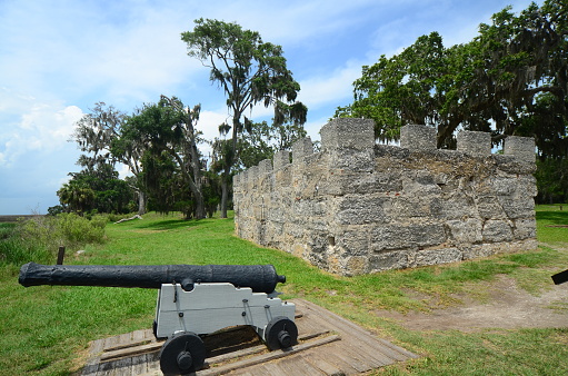 Cannon pointing out over Fancy Bluff Creek (Frederica River on some maps) at Fort Frederica. Fort Frederica National Monument is managed by the National Park service and is located on St. Simons Island in Coastal southeast Georgia, USA. Built in 1776, a British garrison was stationed there to guard against Spanish attack from Florida.