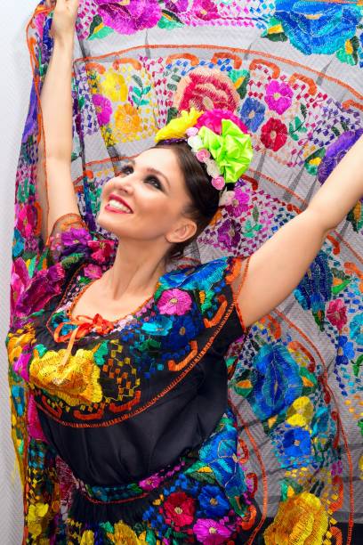 schönes lächeln mexikanerin im mexikanischen tracht nands, halten den rock als hintergrund wie pfau - embroidery needlecraft product dress pattern stock-fotos und bilder