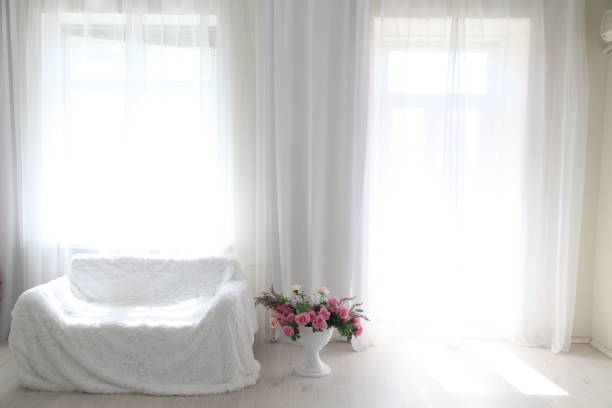 istock Interior white room sofa flowers light from the window 804477770