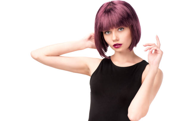 young stylish woman with purple hair posing and looking at camera isolated on white young stylish woman with purple hair posing and looking at camera isolated on white purple hair stock pictures, royalty-free photos & images