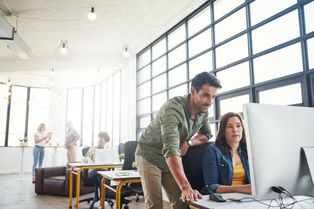 She’s ready to strike out on her own Shot of a male designer assisting his colleague at her desk small office stock pictures, royalty-free photos & images