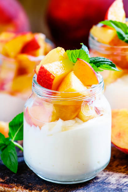 istock Sweet yogurt with peach and mint in glass jar, selective focus 804495052