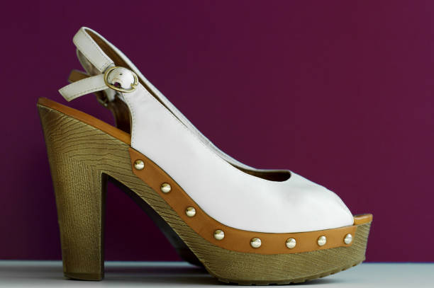 White summer shoes for female on high heels on purple background. Women's footwear fashion concept