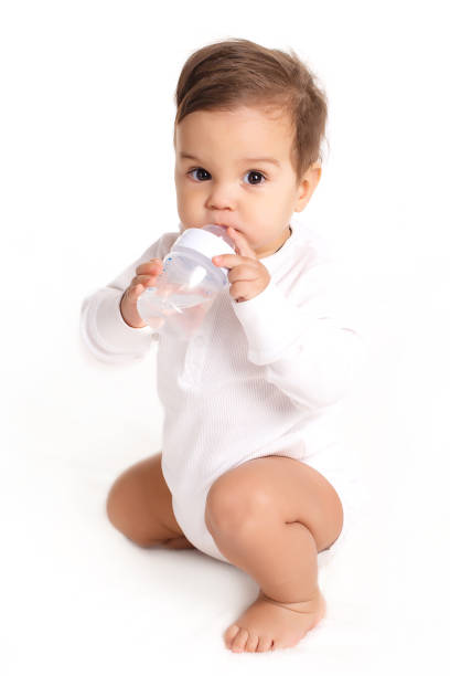istock Sweet baby holding bottle and drinking water 804497932
