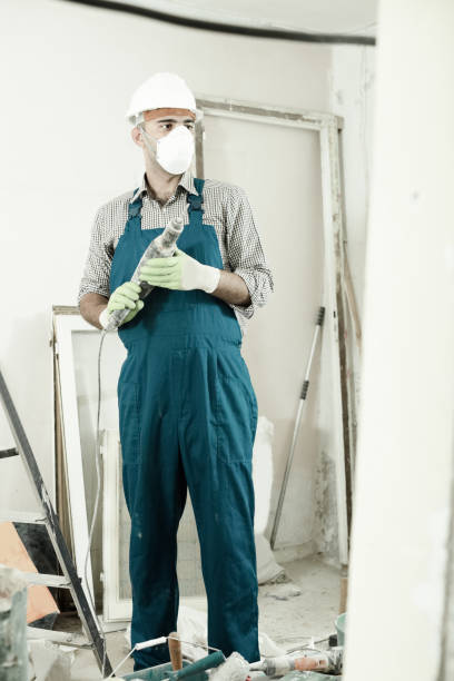 istock Repairman in helmet is perforating wall with drill 804500956