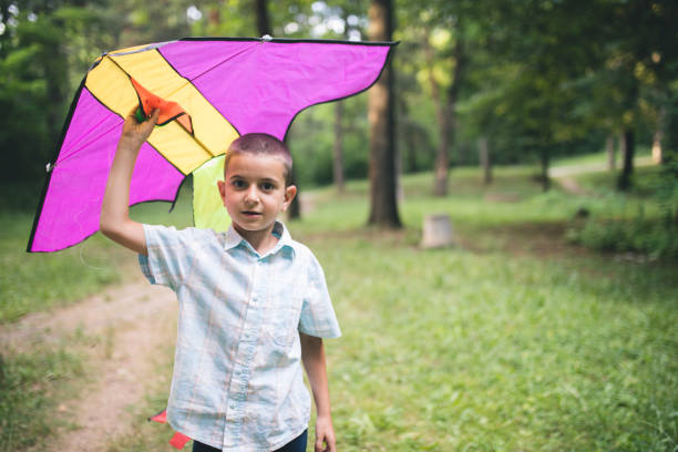 istock Happy and smiling boy playingin with kite outdoor 804507614