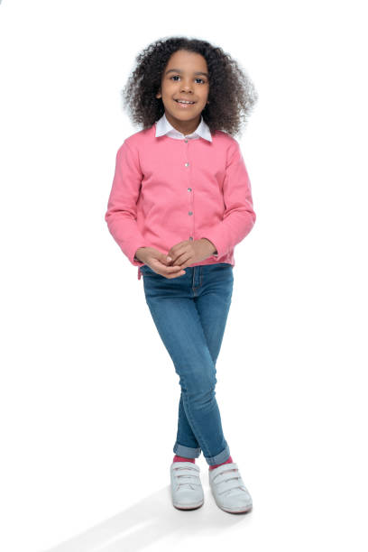 lächelnde afroamerikanische mädchen posiert in rosa strickjacke isoliert auf weiss - full length child little girls only children only stock-fotos und bilder
