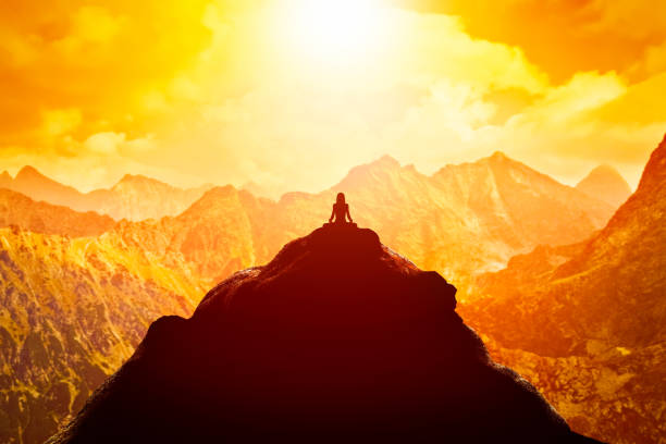 woman meditating in sitting yoga position on the top of a mountains above clouds at sunset. - sacred mountain imagens e fotografias de stock