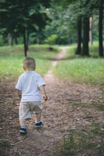 istock cute baby boy walking in spring forest 804523410