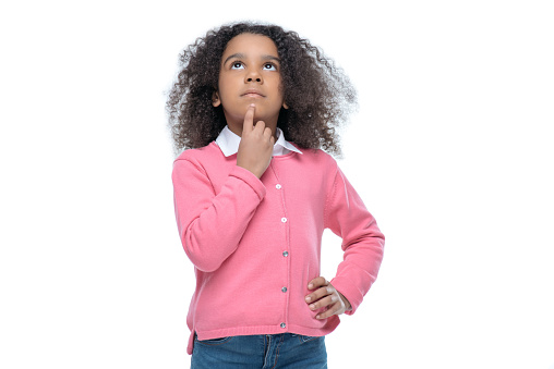 little thoughtful african american girl in pink cardigan isolated on white