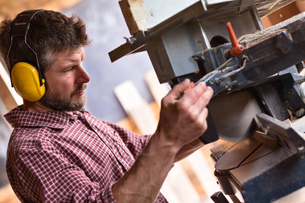 istock Male Carpenter cutting plank by circular saw 804543920